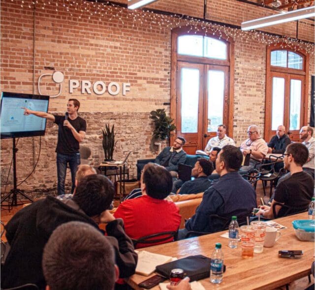 Man presenting slideshow to small audience in start-up office