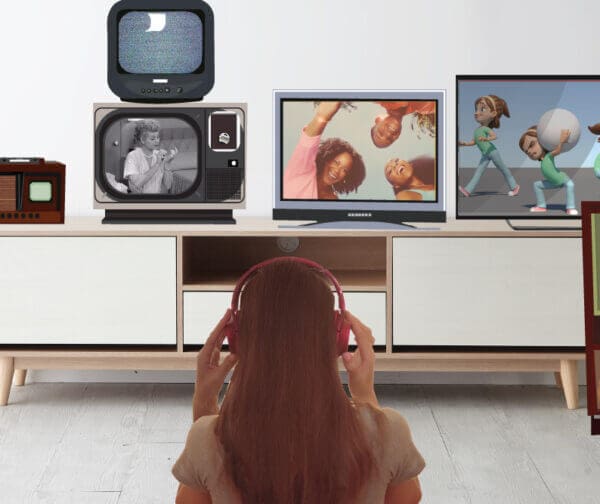 Women sitting Infront of multiple screens with headphones