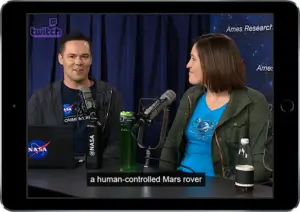 Individuals talking into a microphone with Captions on screen